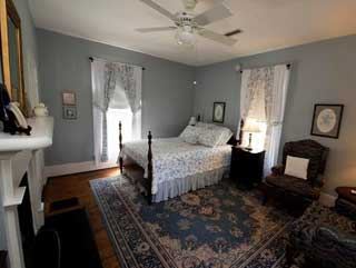 The Cochran Room, a blue grey bedroom with a fireplace