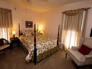 The McLeod Room, a four poster bed in warm lamplight